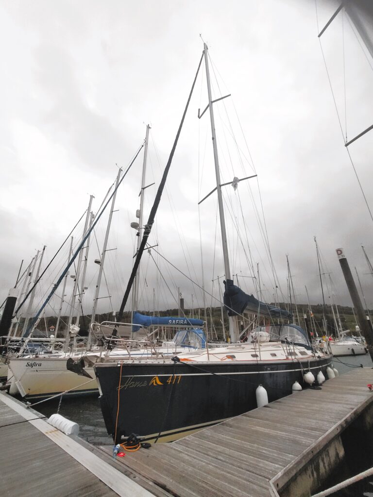 Bolero on the pontoon - it's a fairly standard yacht with a dark blue hull. The precise model is a Hanse 411, if that matters to you.